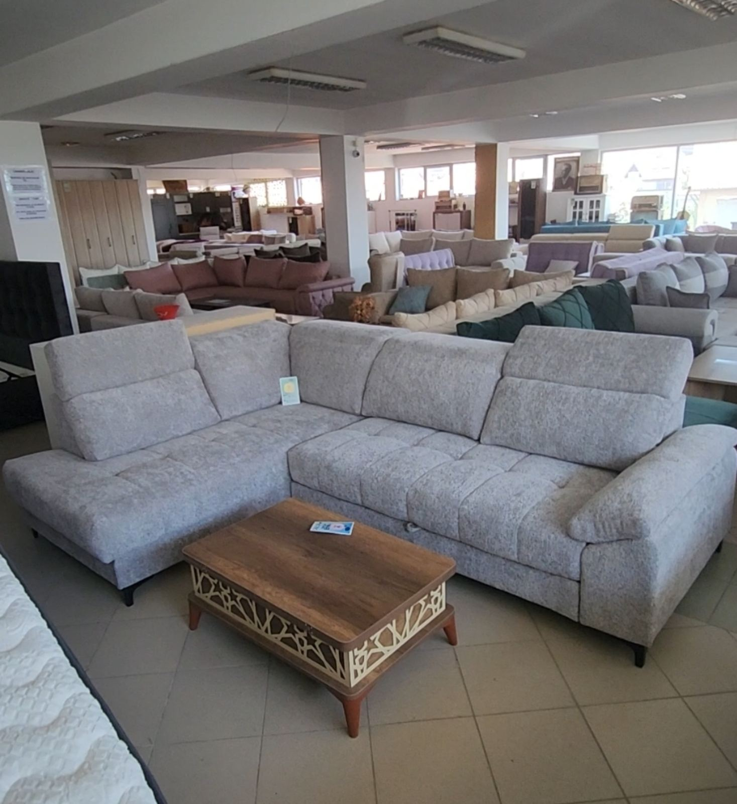 Siva ugaona garnitura sa podesivim naslonima u showroom-u