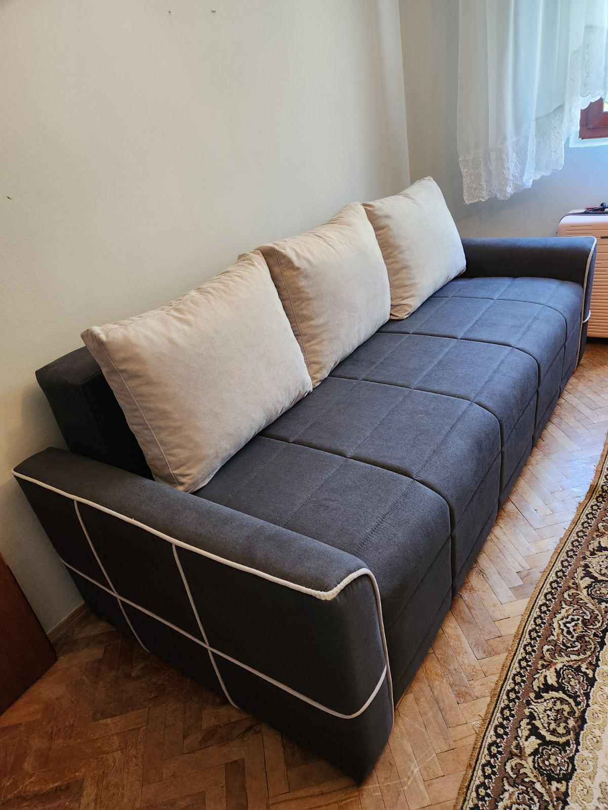 Tamnosivi trosed sa svetlim jastucima